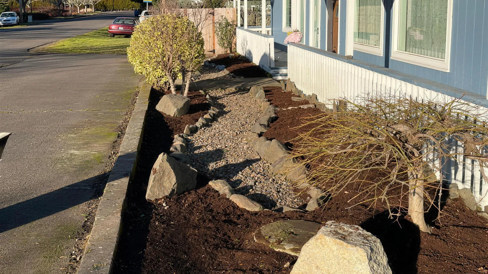 Front yard bed in Salem after a cleanup by Jose's Lawn Services, fresh bark and a reset rock line
